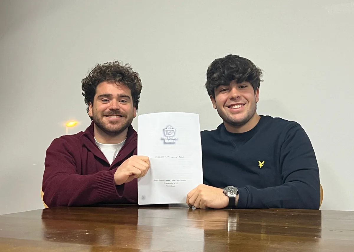 Los cofundadores de MySmartBasket sonriendo y sosteniendo el business plan del proyecto